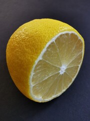 Half a lemon on a black background, shot close-up.