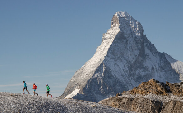 Side view of three athletes in running of trail at Matterhorn