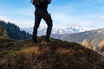 Hiker man with scenic view of snow covered mountain range Julian Alps seen from Karawanks in...
