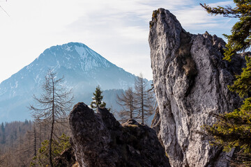 Unique rock formation with scenic view on mountain peak Mittagskogel (Kepa) in Karawanks mountains in Carinthia, Austria. Misty and magical atmosphere in remote landscape in Slovenian Austrian Alps