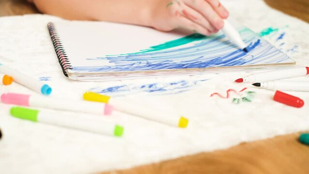 Unrecognizable child drawing with a green felt-tip pen on a sheet of paper. Dirty stain felt-tip pens on the white upholstered furniture or a carpet. High quality 4k footage
