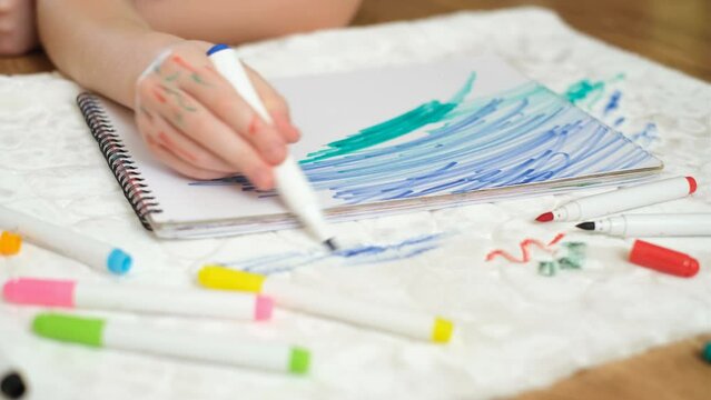 Unrecognizable child drawing with a green felt-tip pen on a sheet of paper. Dirty stain felt-tip pens on the white upholstered furniture or a carpet. High quality 4k footage