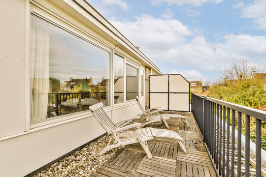 Balcony with two wooden deck chairs