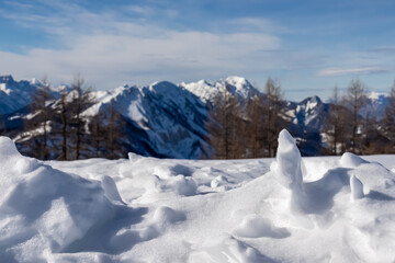 Figures of snow with panoramic view on snow capped mountain peaks of Karawanks and Julian Alps in...