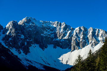 Panoramic view of Karawanks mountain range on sunny day in Carinthia, Austria. Looking at snow...