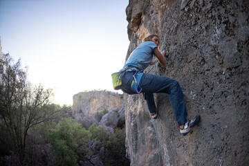 A woman climbs a rock