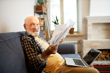 Side view of worried anxious elderly man in glasses looking at camera with panic facial expression...