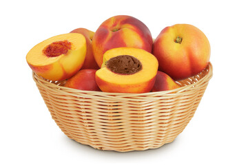 Ripe nectarine fruit with half in a wicker basket isolated on white background with full depth of field