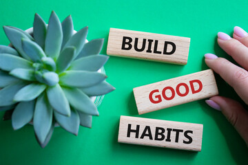 Build good habits symbol. Wooden blocks with words Build good habits. Beautiful green background with succulent plant. Businessman hand. Business and Build good habits concept. Copy space. - obrazy, fototapety, plakaty