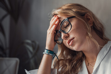 Stressed tired woman in pain having strong terrible headache attack after computer laptop study,...