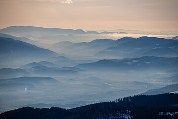 Panoramic view of magical blue mountain range of Lavanttal Alps, Carinthia, Austria. Valley is...