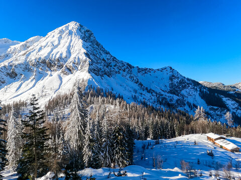 Scenic view on snow capped mountain peak of Mittagskogel (Kepa) in Karawanks, Carinthia, Austria, Europe. Winter wonderland in Austrian Alps. Snowshoe hiking through remote forest and snowy landscape