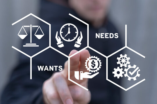 Man using virtual touch screen sees words: WANTS NEEDS. Concept of Wants Needs Desires. Business, financial wellness, budgeting, planning, psychological wants needs and desires concept.