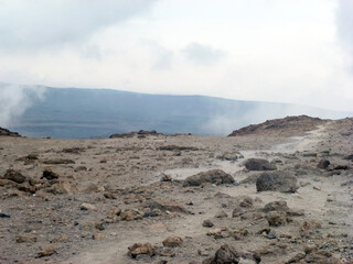 A large desert valley in the mountains with piles of stones. Desert landscape
