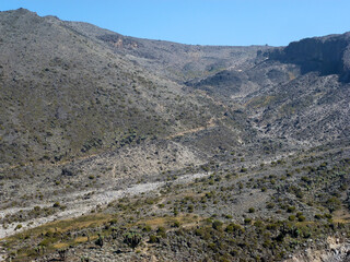 A large desert valley in the mountains with piles of stones. Desert landscape