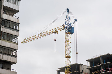 Fototapeta premium A large crane is constructing a new building in Ukraine. Restoration after the war.