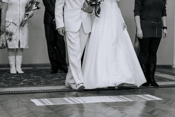 The bride and groom walk, stepping on an embroidered towel at the ceremony. Wedding photography,...