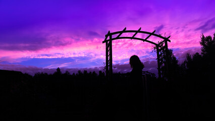 Silhouette of a woman on the background of a colorful sunset - obrazy, fototapety, plakaty