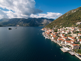 Fototapeta na wymiar Coast of Perast with ancient houses and church bell tower. Montenegro. Drone