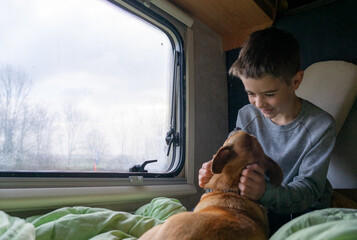 Boy with his dog in the bed of a motorhome. camper life