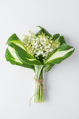 Lily of the valley flowers bouquet on white background. Womens day, Valentines day card. Top view. Flat lay. Vertical orientation
