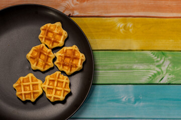waffles on a black plate set on a multicolored background