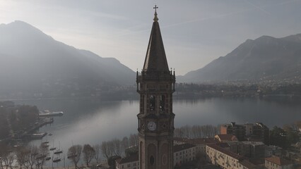 the Basilica of San Nicolo is located in the heart of Lecco, in an elevated position near lake Como at Christmas time and the statue of Mario Cermenati.  - obrazy, fototapety, plakaty