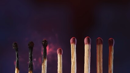 A row of matches on a dark studio background. Three matches are burned and charred, but five remain...