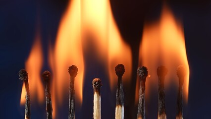 Row of burning matches. Matches burning and illuminating the dark studio space with light and...