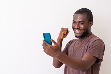 Overjoyed african black man look at cellphone feeling joyful reading good news. African man using...