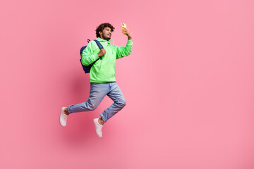 Fototapeta na wymiar Full body photo of influencer blogger beginner young student indian guy using smartphone wear backpack isolated on pink color background