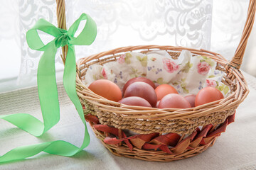 Easter eggs in the basket of wooden boards