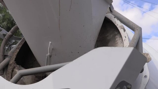 Truck with cement mixer working. Concrete mixer rotating. Closeup of white cement truck mixing concrete.