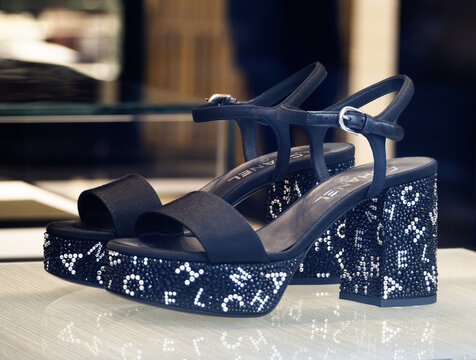 Sandals with  rhinestones and silver letters by Chanel.Blurred background.Milan - Italy,12 December 2023