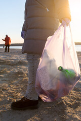 volunteers clean up trash on the beach. environmental problems of plastic in the ocean. vertical photo