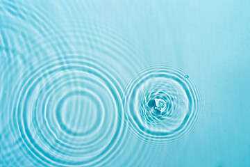 Transparent blue clear water surface texture with ripples Circles and waves on blue water in...