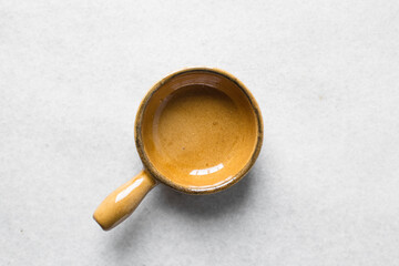Top view of brown ceramic ramekins on  a white marble countertop, terracotta ramekins with handles on a white background