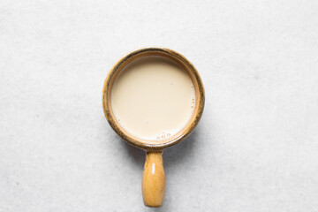 Top view of evaporated milk in a brown ceramic ramekin, vegan and alternative milk in a ceramic ramekin with handle, milk for baking - obrazy, fototapety, plakaty