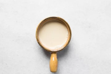 Fotobehang Top view of evaporated milk in a brown ceramic ramekin, vegan and alternative milk in a ceramic ramekin with handle, milk for baking © this_baker