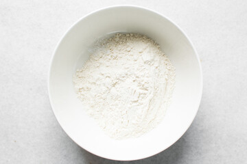 All purpose flour in a white bowl, baking flour in a bowl