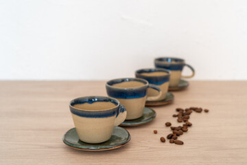 Set of four cups with saucers on a wooden table. High quality photo. Pottery, handmade