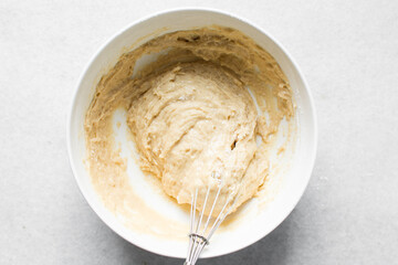 vanilla almond muffins batter in a white mixing bowl, almond muffins batter in a white ceramic bowl, process of making almond muffins