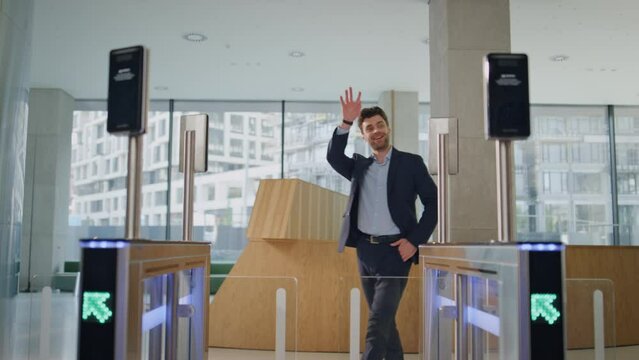 Man open automatic door turnstile using smartwatch in office building smiling.