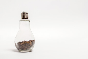 Obraz na płótnie Canvas Light bulb with coffee beans, bottle with coffee beans