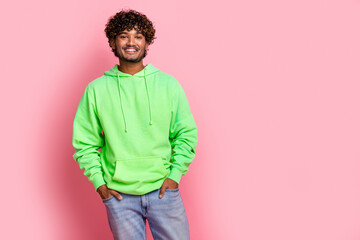 Photo of toothy smiling arabian young guy in green hoodie candid model posing in casual outfit isolated on pastel pink color background