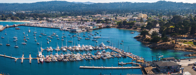 Beautiful aerial view of the Monterey town in California with many yachts docked by the pier. - obrazy, fototapety, plakaty