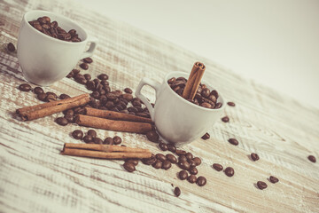 Aromatic coffee seeds and a cup of coffee on a wooden table