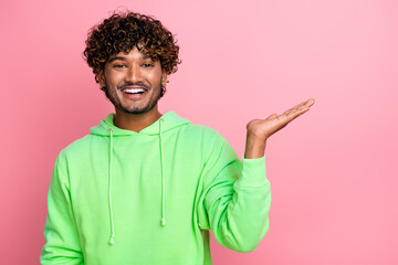 Photo of smiling young arabian curly haired boyfriend holding palm showing dating app for beginners...