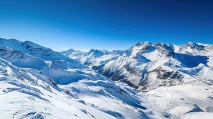 Panoramic view of a snowy mountain range under a clear blue sky.