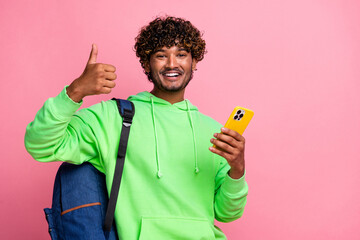 Portrait of optimistic new iphone user young arabian curly haired guy shows like symbol thumb up...